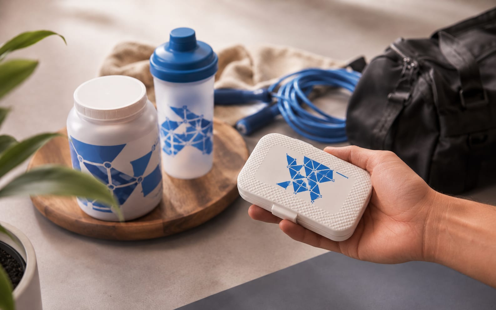 Geöffneter Versandkarton einer Supplement-Marke mit Kapseldose und bedruckter Pillenbox als Zugabe